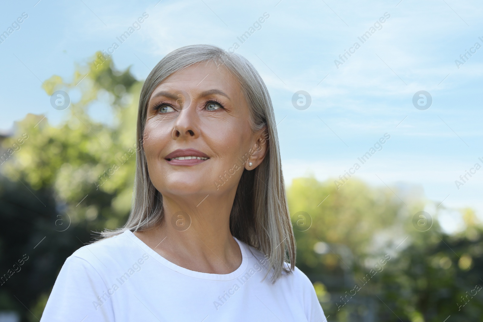 Photo of Portrait of beautiful happy senior woman outdoors, space for text