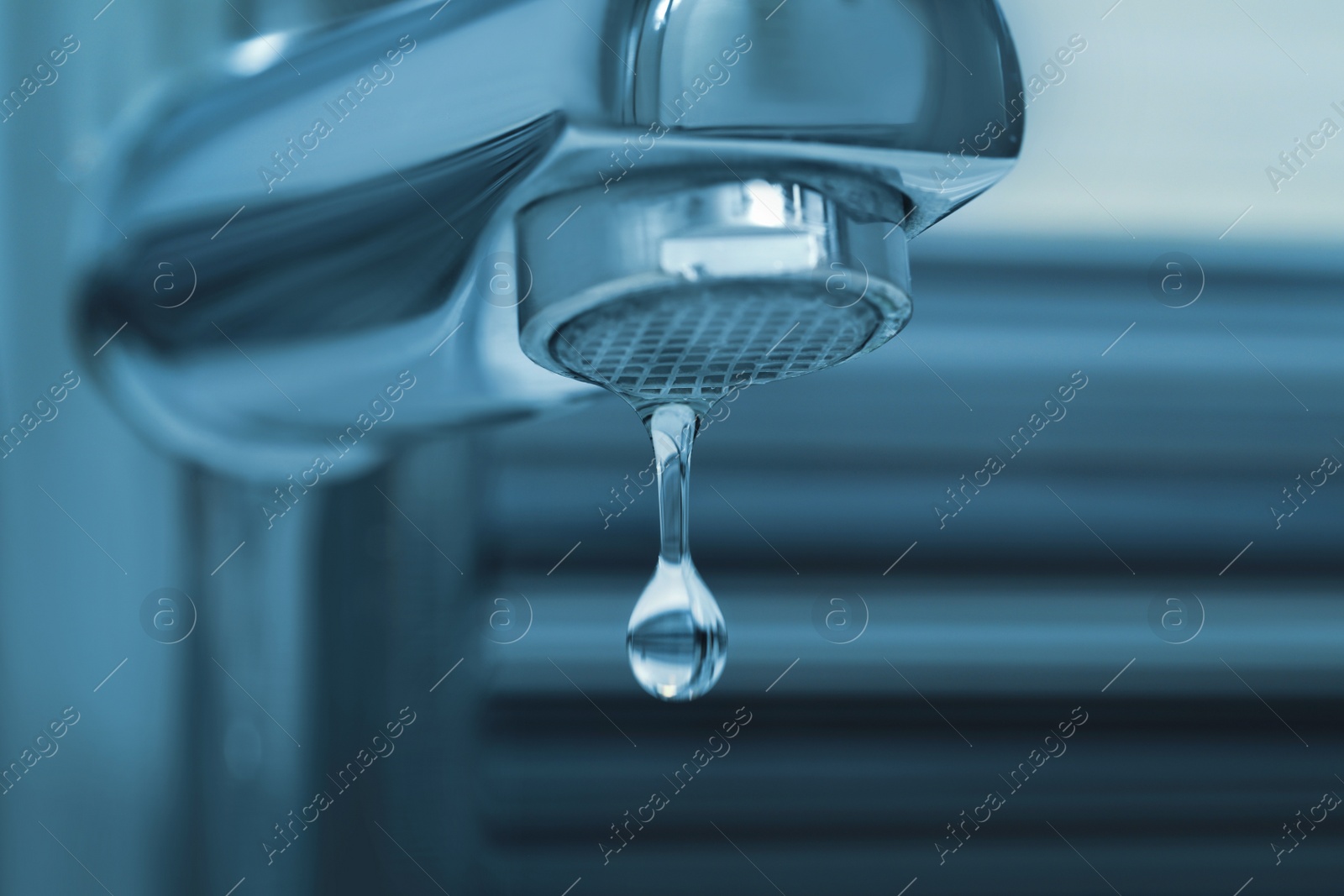 Image of Water drop falling down from tap on blurred background, closeup