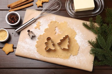 Making Christmas cookies. Flat lay composition with cutters and raw dough on wooden table