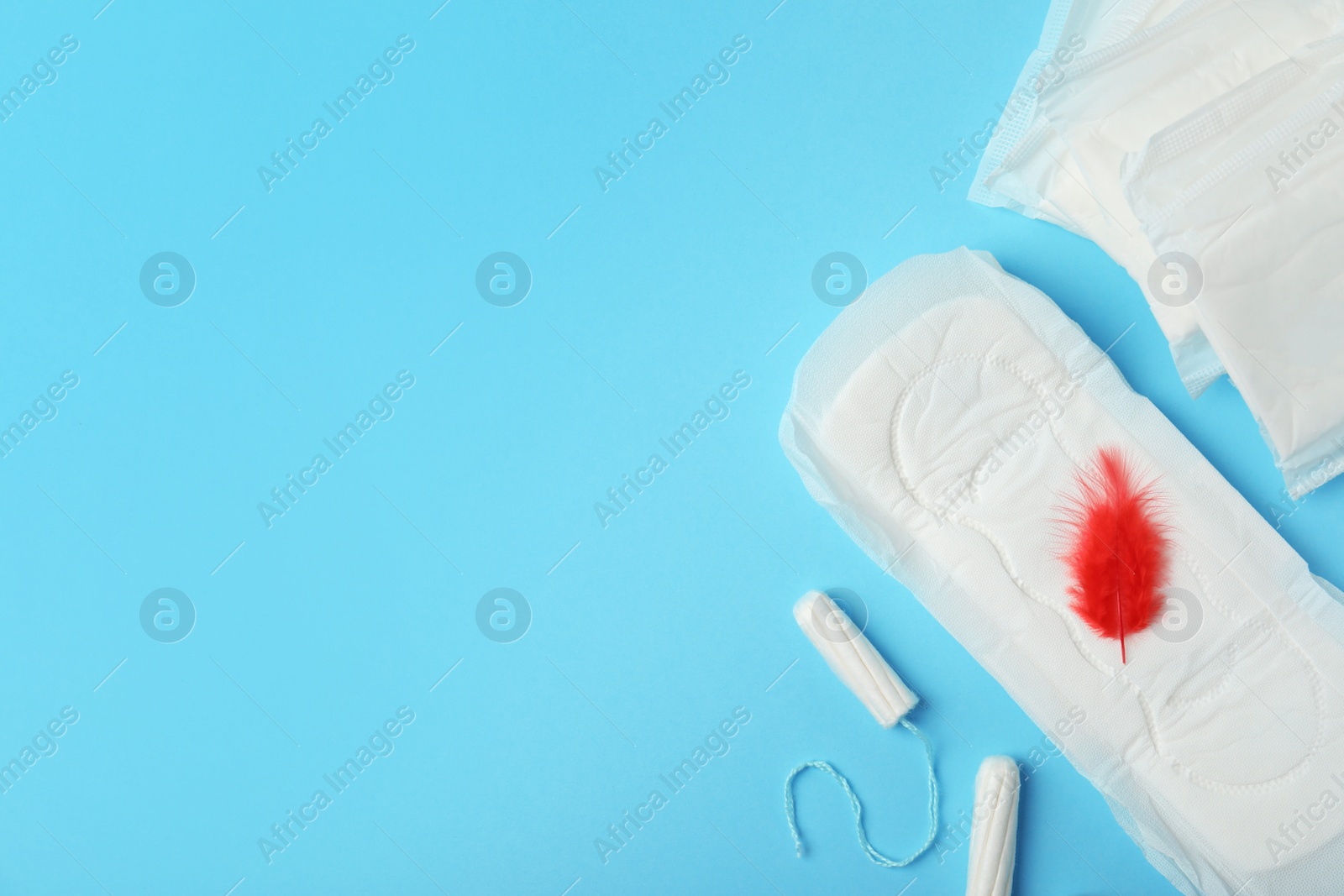 Photo of Flat lay composition with cotton pads and space for text on light blue background. Gynecological care