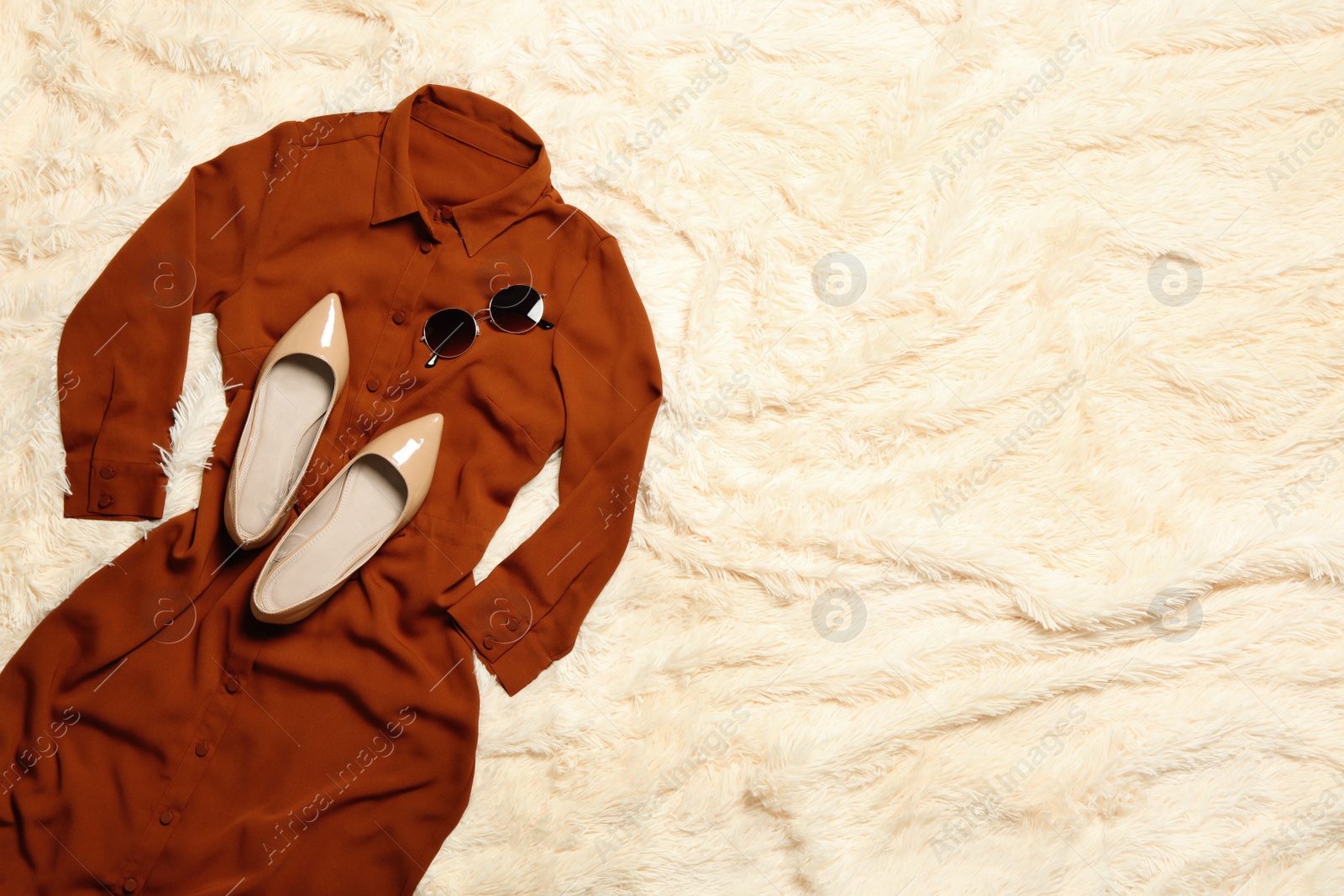 Photo of Stylish dress, shoes and sunglasses on beige blanket, flat lay. Space for text