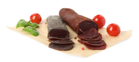 Photo of Delicious dry-cured beef basturma with basil and tomatoes on white background