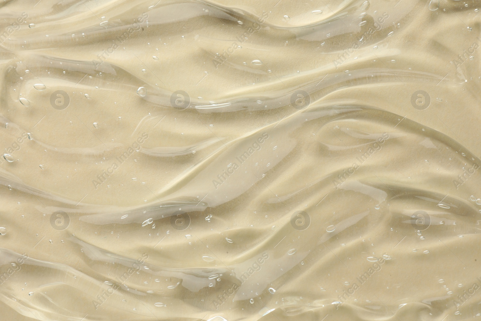 Photo of Clear cosmetic gel on beige background, top view