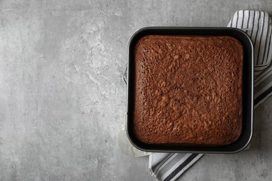Photo of Homemade chocolate sponge cake on light grey table, top view. Space for text