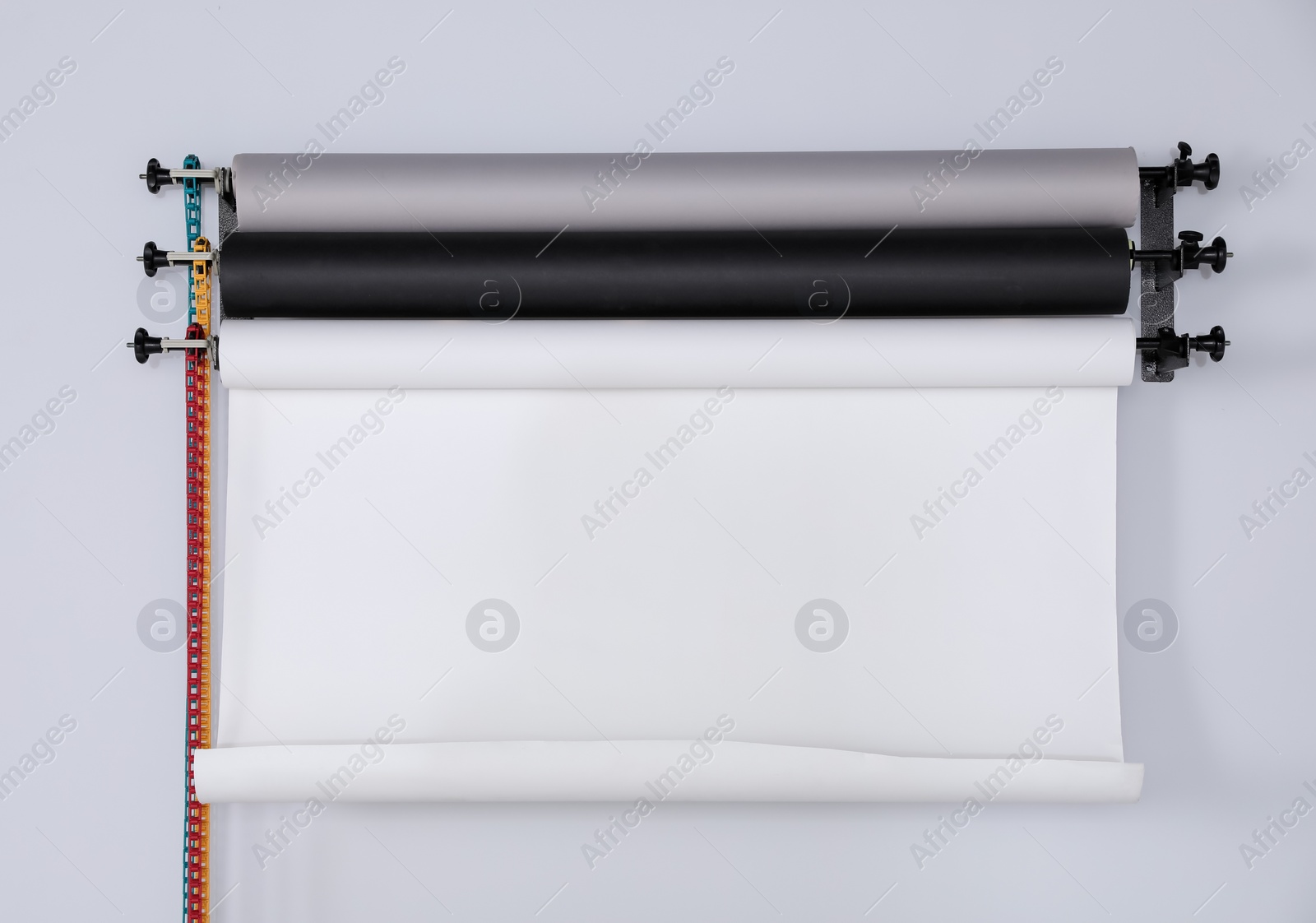 Photo of Colorful photo background rolls on white wall in studio