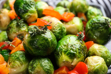 Photo of Delicious roasted Brussels sprouts with bell pepper as background, closeup