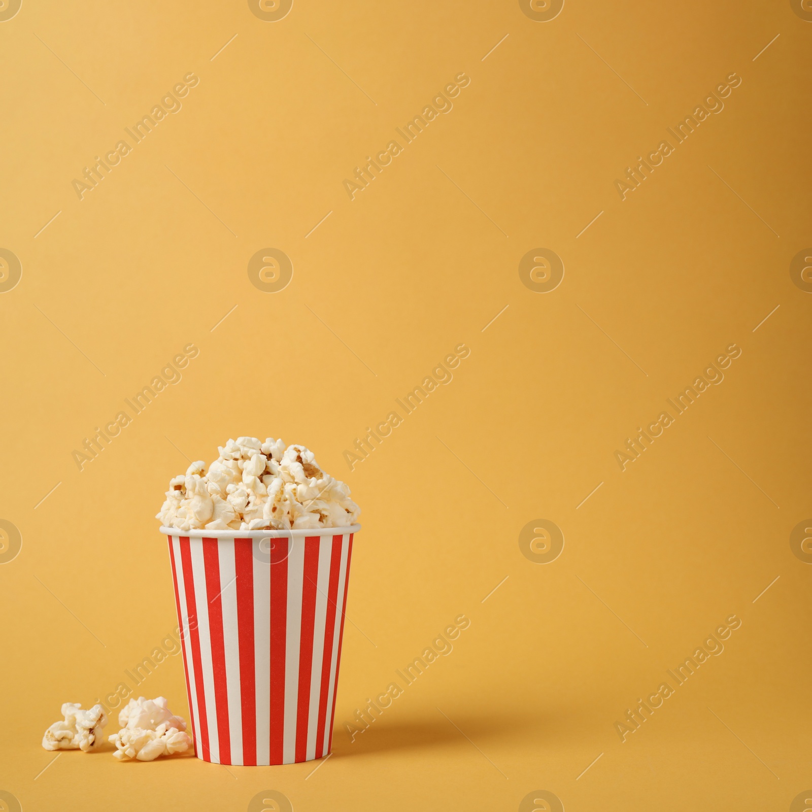 Photo of Delicious popcorn on yellow background. Space for text