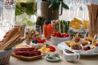 Variety of snacks on wooden table in buffet style indoors