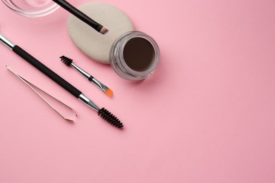 Photo of Eyebrow pomade with henna effect and professional tools on pink background, flat lay. Space for text