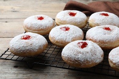 Photo of Many delicious donuts with jelly and powdered sugar on wooden table