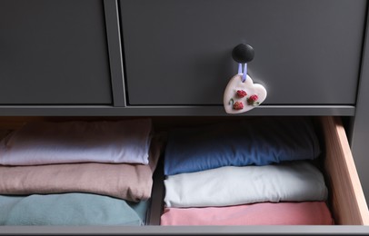 Dresser with heart shaped scented wax sachet and open drawer, closeup