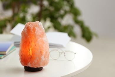 Himalayan salt lamp on table indoors, space for text