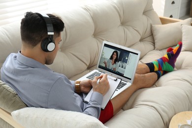 Businessman in shirt and underwear having video call on laptop at home