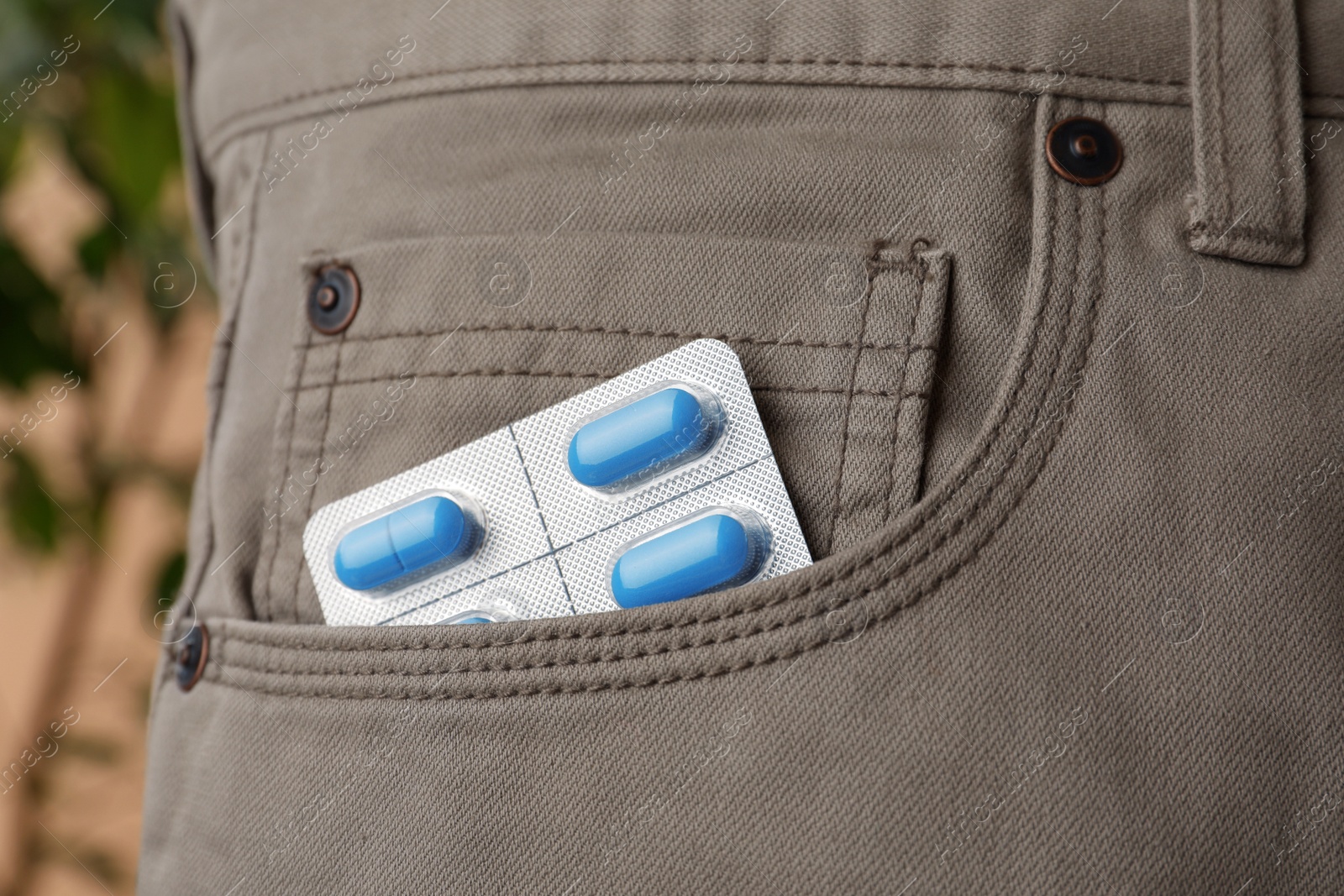 Photo of Pants with pills in pocket, closeup. Potency problem concept