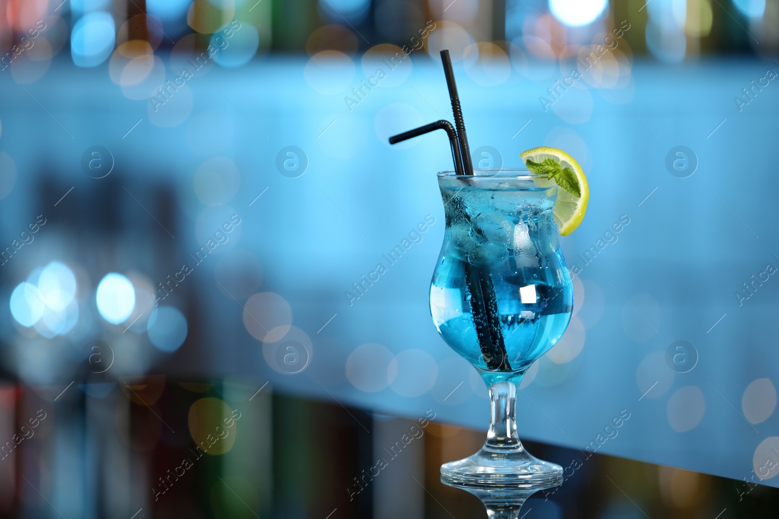 Photo of Glass of fresh alcoholic cocktail on bar counter. Space for text