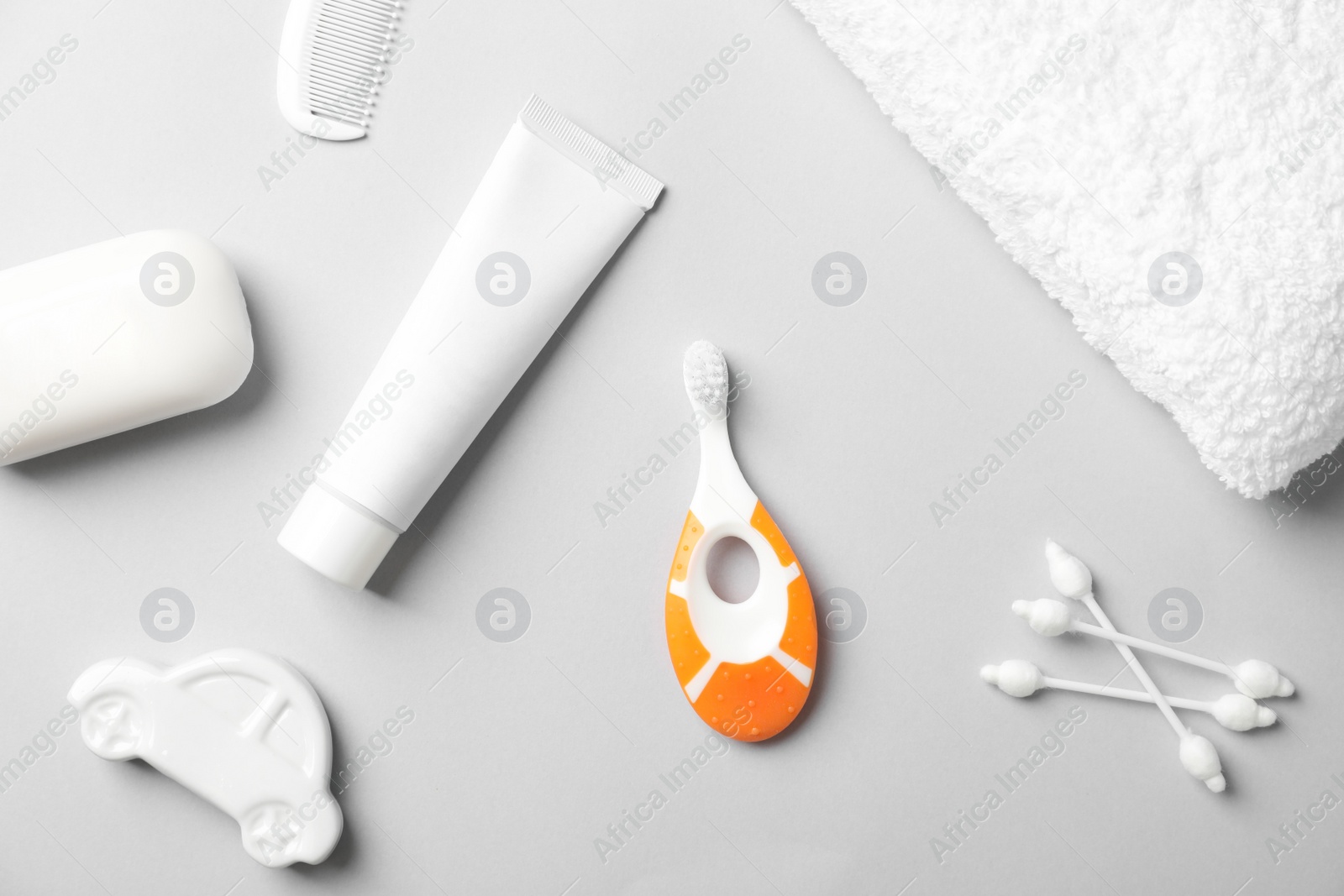 Photo of Flat lay composition with baby toothbrush and toiletries on color background