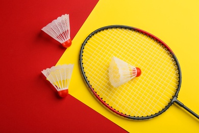Photo of Badminton racket and shuttlecocks on color background, flat lay