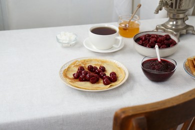 Photo of Vintage samovar, cup of hot drink and snacks served on table, space for text. Traditional Russian tea ceremony