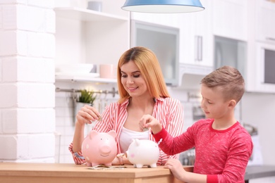 Photo of Family with piggy banks and money at home