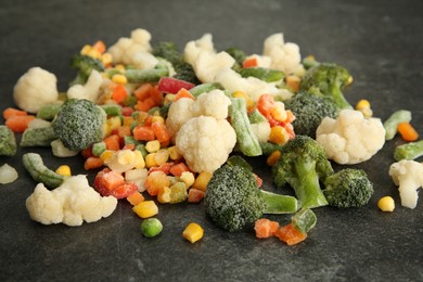 Mix of different frozen vegetables on gray table, closeup