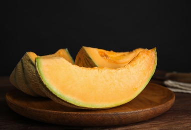 Tasty fresh cut melon on wooden tray, closeup