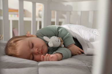 Photo of Cute little baby sleeping in crib at home. Bedtime