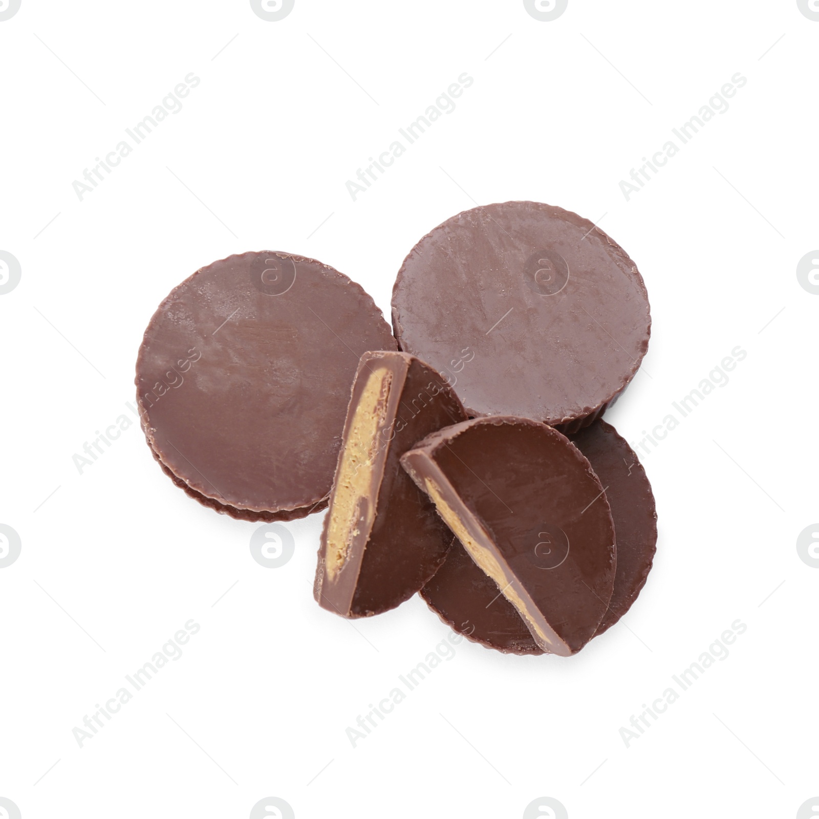 Photo of Cut and whole delicious peanut butter cups on white background, top view