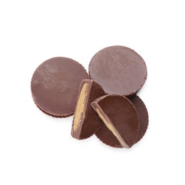 Cut and whole delicious peanut butter cups on white background, top view