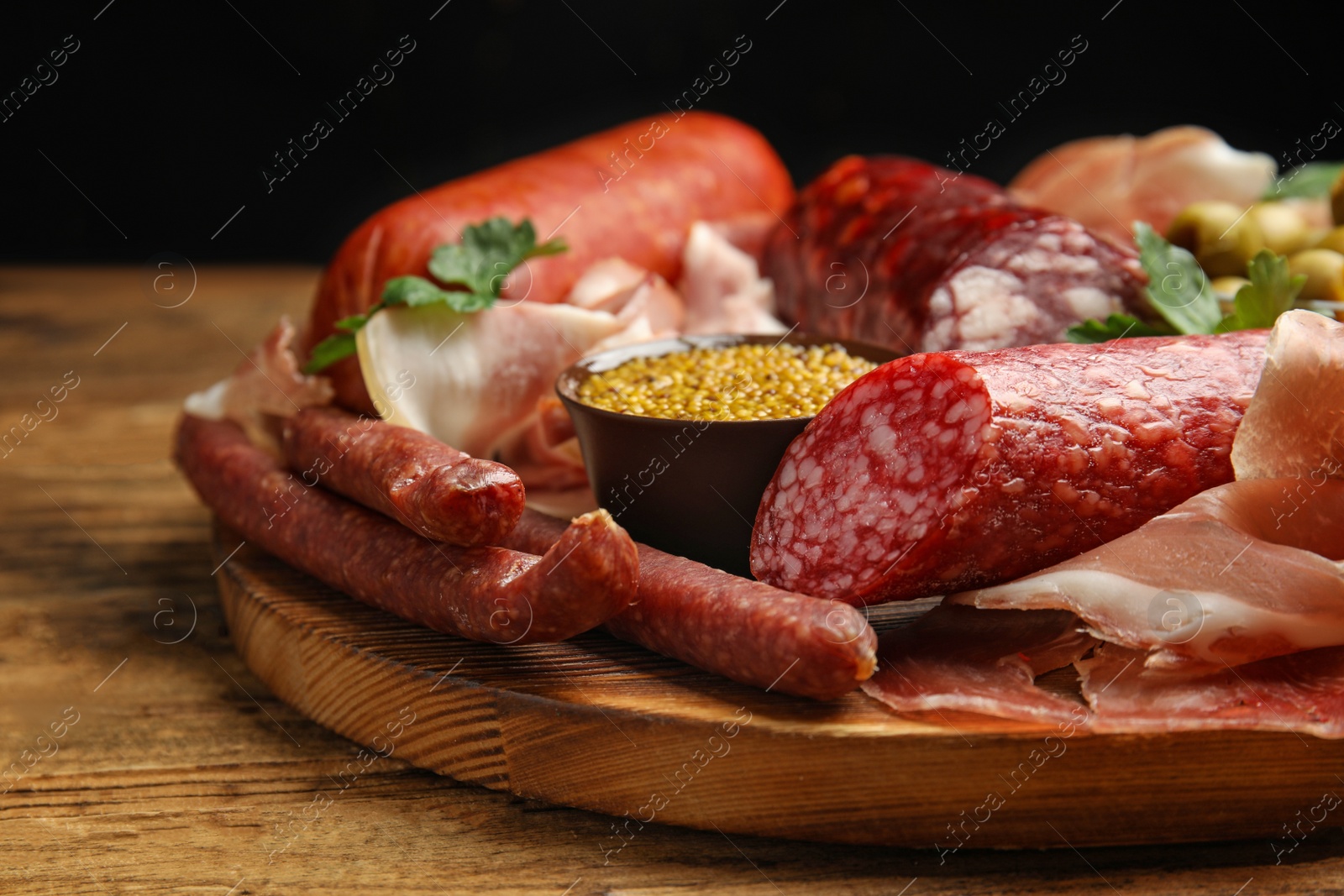 Photo of Different types of sausages served on wooden table, closeup