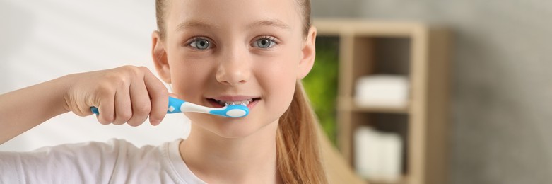 Image of Cute little girl brushing her teeth with plastic toothbrush in bathroom. Banner design with space for text