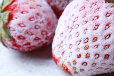Photo of Frozen ripe strawberries on light table, closeup view