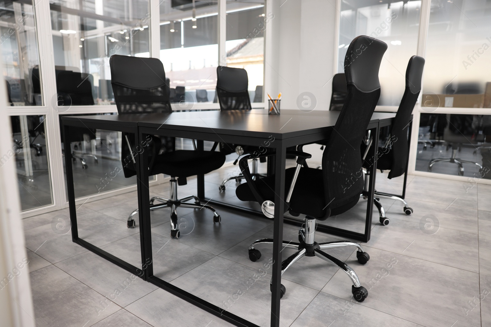 Photo of Comfortable office chairs and tables in meeting room