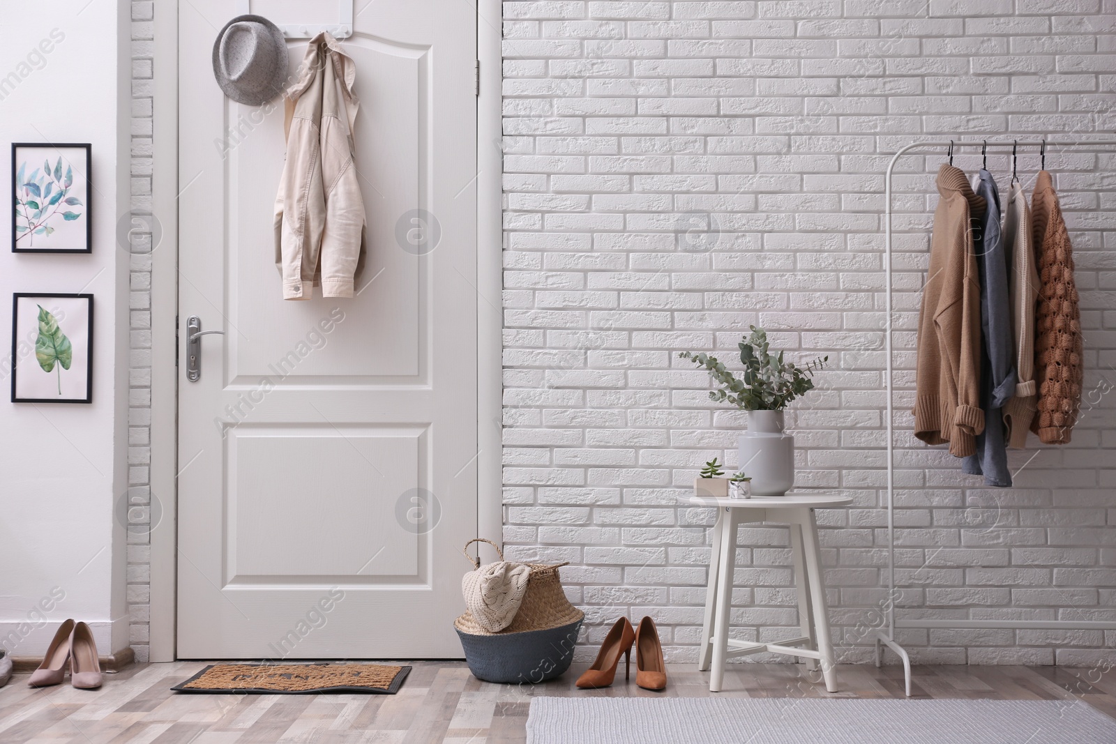 Photo of Vase with fresh eucalyptus branches on table in entryway. Interior design