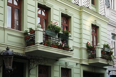 Exterior of beautiful residential building with flowers on balconies