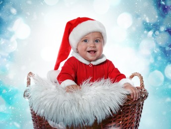 Image of Cute baby in wicker basket against blurred lights. Christmas celebration