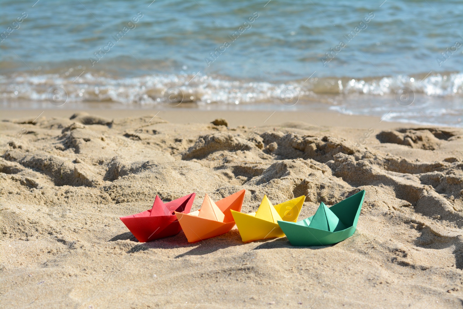 Photo of Many paper boats near sea on sunny day