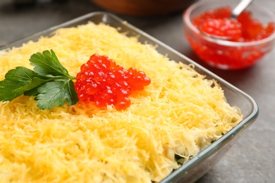 Photo of Traditional russian salad Mimosa on grey table, closeup