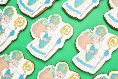 Photo of Tasty cookies on green background, flat lay. St. Nicholas Day celebration