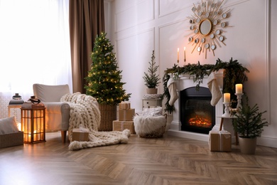 Stylish room interior with fireplace and beautiful Christmas tree