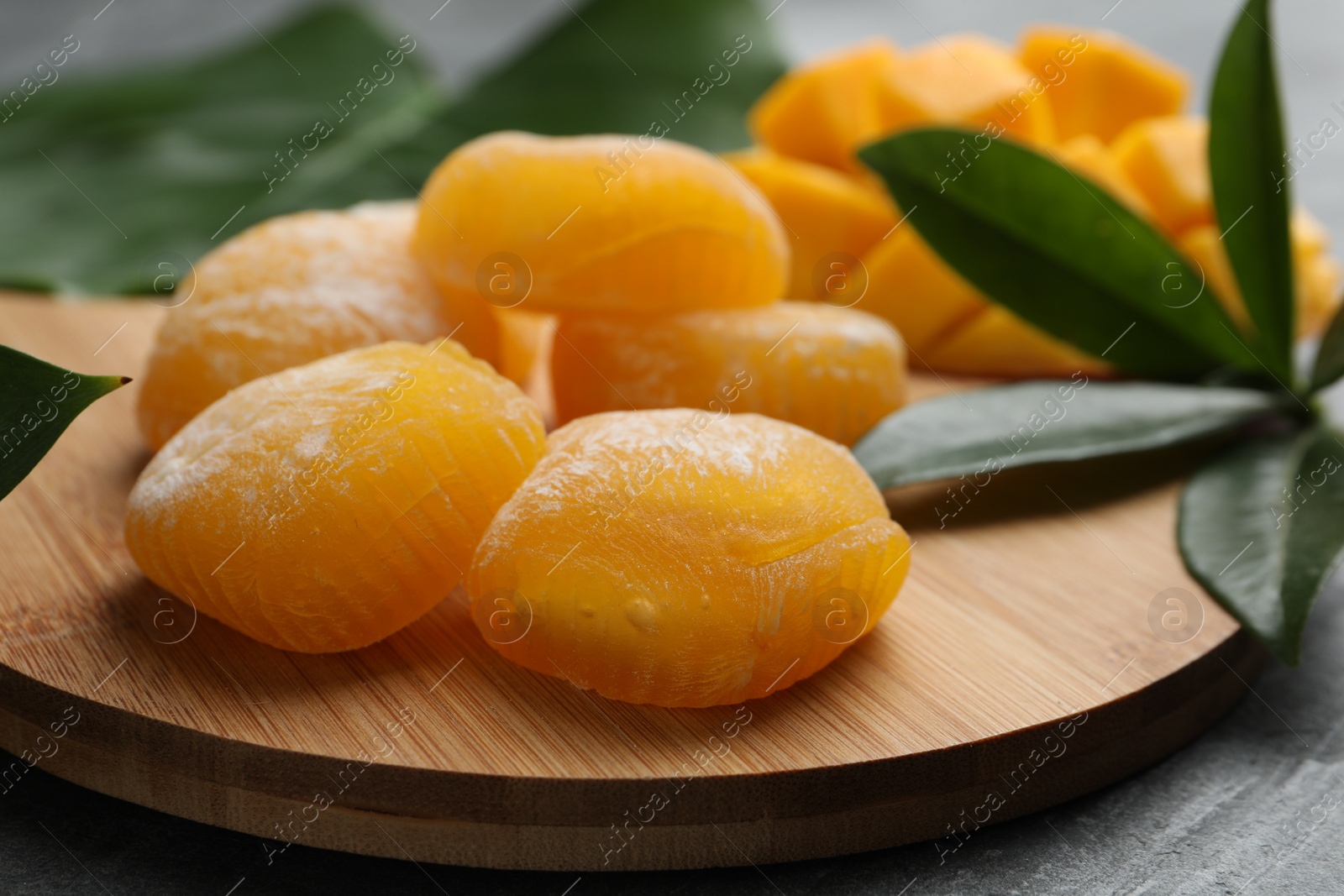 Photo of Delicious mango mochi on wooden board, closeup