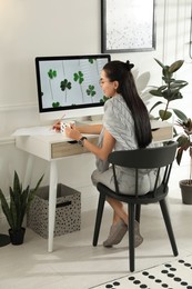 Young woman working at table in light room. Home office