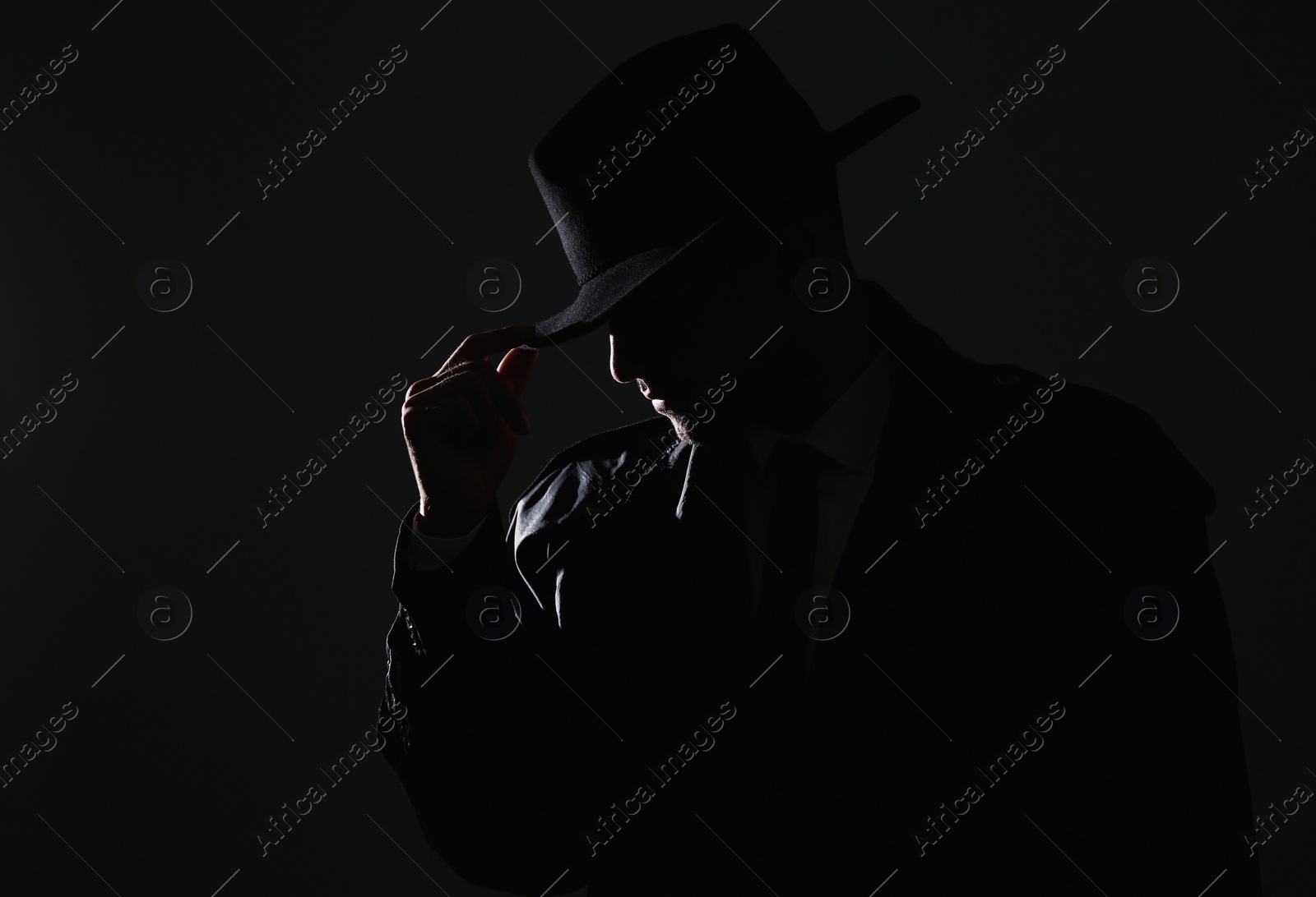 Photo of Old fashioned detective in hat on dark background