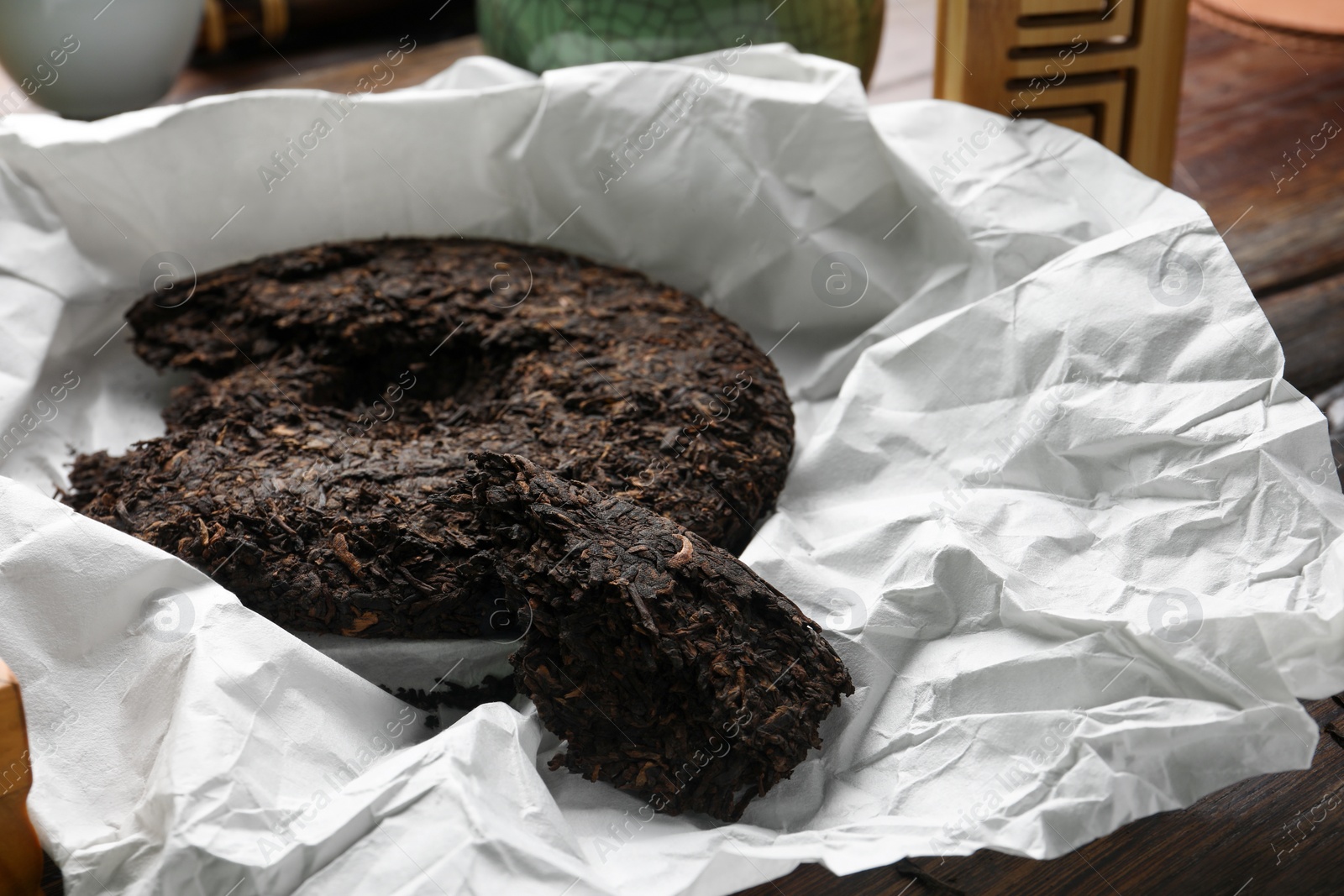 Photo of Broken disc shaped pu-erh tea on wooden table