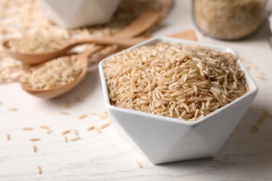 Uncooked brown rice in bowl on table