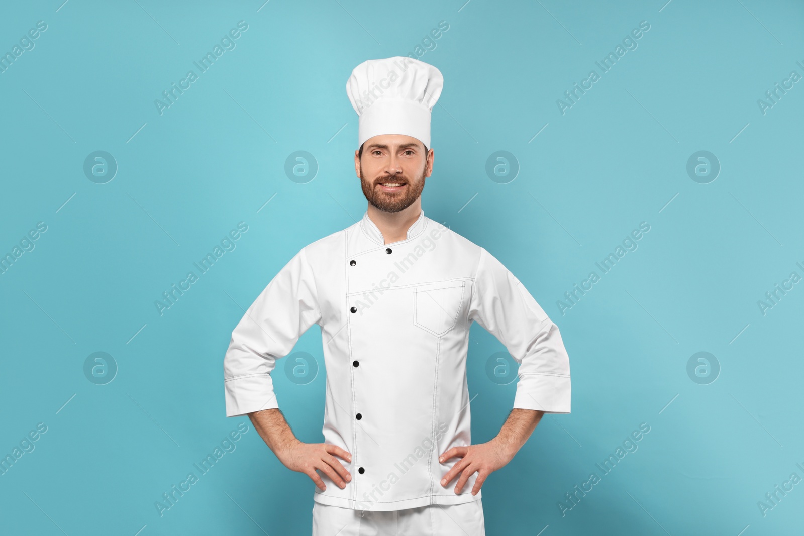 Photo of Smiling mature chef on light blue background