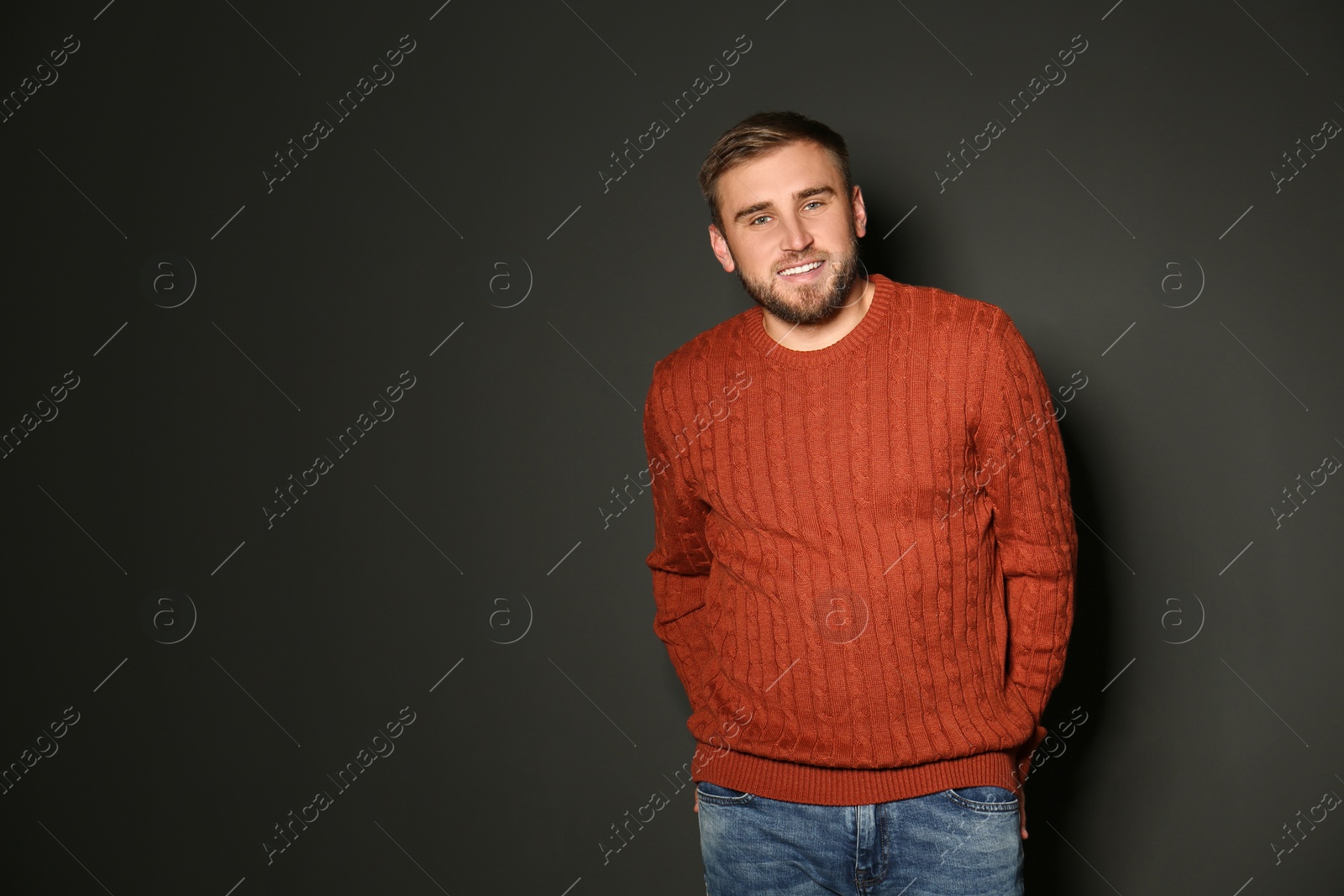 Image of Handsome man wearing warm sweater on dark background 