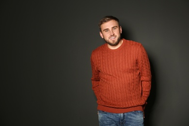 Handsome man wearing warm sweater on dark background 