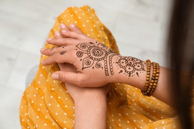 Woman with beautiful henna tattoo on hand, above view. Traditional mehndi