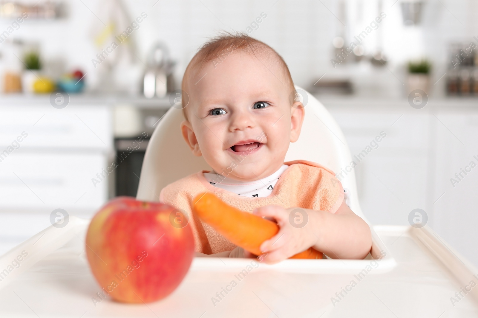Photo of Adorable little child having breakfast in highchair indoors. Healthy baby food
