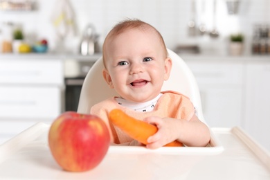 Adorable little child having breakfast in highchair indoors. Healthy baby food